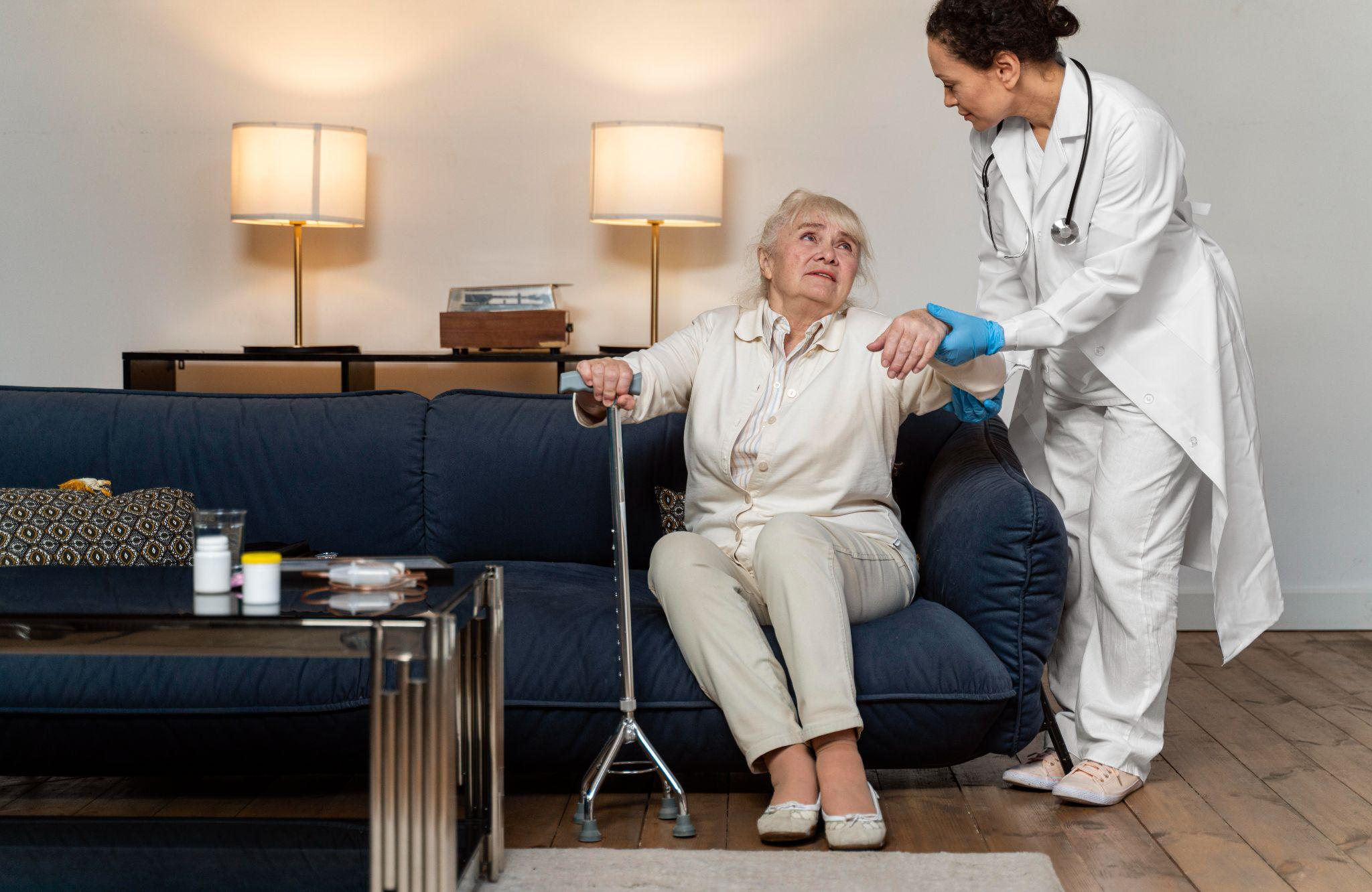 Caregiver helping a senior stand after hospital discharge during recovery