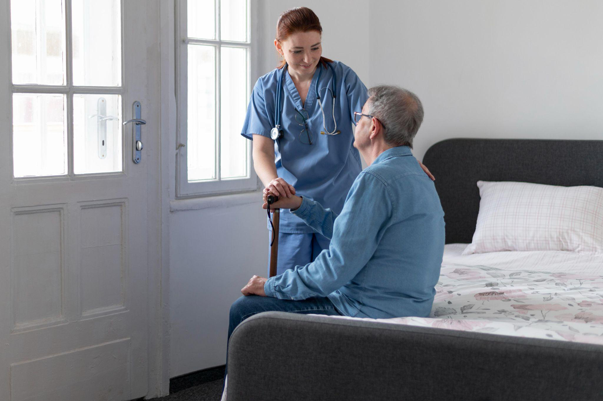  nurse assisting a senior man in a bedroom during transition to nursing home care environment