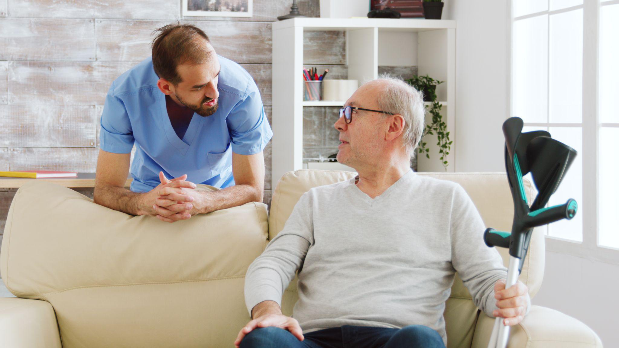 Personal care assistant in NJ talking with an older adult during a senior home care visit